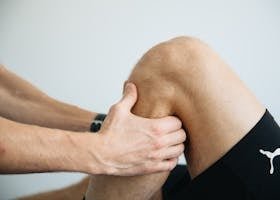 Detailed image of a physiotherapy session focusing on knee massage treatment.